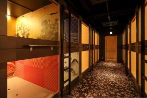 einen Flur eines Zimmers mit Gemälden an den Wänden in der Unterkunft NINJA & GEISHA in Osaka