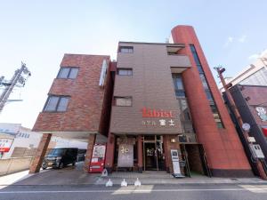 a building on a street with chickens in front of it at Tabist ホテル富士 in Daisen