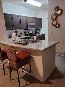 a kitchen with a counter with chairs and a sink at Cozy 1bd in the heart of downtown Dallas!(w/parking) in Dallas