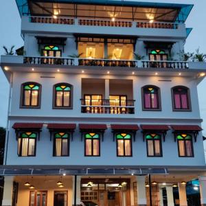 a large white building with windows and a balcony at Meghdoot river resort in Ernakulam