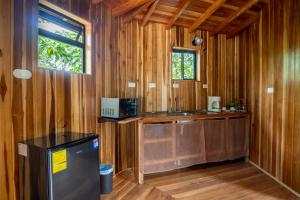 a bathroom with wooden walls and a sink and a window at Casitas del Bosque Monteverde. in Monteverde Costa Rica