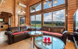 a living room with leather furniture and large windows at Nice Home In Ravna Gora With House A Panoramic View in Ravna Gora