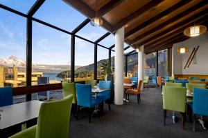 un restaurante con vistas al agua y a las montañas en Copthorne Hotel & Apartments Queenstown Lakeview en Queenstown