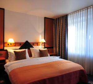a hotel room with a large bed and a window at Hotel Flandrischer Hof in Cologne