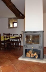 a living room with a fireplace with logs in it at Retiro da Lameira in Seia