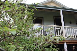 a house with a porch with a white railing at Lottie’s Bed & Breakfast at Fielderberry Farm in Cockatoo