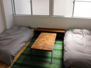 那智勝浦的住宿－WhyKumano，客房设有两张床和一张木桌。