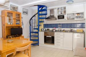 una cocina con mesa y una escalera de caracol azul en Apartment Oscar, en Sitges