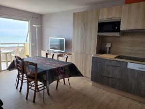 eine Küche und ein Esszimmer mit einem Tisch und einem TV in der Unterkunft Appartement Merlimont, 3 pièces, 6 personnes - FR-1-672-6 in Merlimont