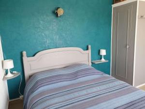 um quarto com uma cama com uma parede azul em Maison Merlimont, 3 pièces, 4 personnes - FR-1-672-19 em Merlimont