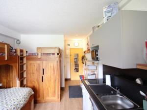 a small kitchen with a sink and a bed at Studio Chamrousse, 1 pièce, 3 personnes - FR-1-549-95 in Chamrousse
