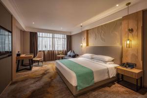um quarto de hotel com uma cama e uma escrivaninha em Wuhan Hongguang Hotel em Wuhan