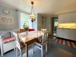 a kitchen and dining room with a table and chairs at Holiday home ULRIKA II in Rimforsa