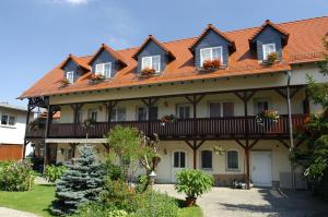 ein großes Haus mit rotem Dach in der Unterkunft Pension Lindenhof in Kromsdorf