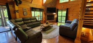 a living room with leather furniture in a log cabin at S'more Fun in Sevierville