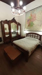 1 dormitorio con 1 cama y un mapa en la pared en La Casona en Godoy Cruz