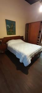 a bedroom with a white bed with a wooden headboard at La Casona in Godoy Cruz