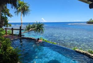 a person in a swimming pool next to the ocean at Savasi Island Resort in Savusavu