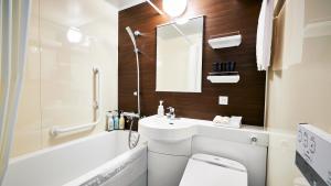 een badkamer met een wastafel, een toilet en een spiegel bij Hotel Monte Hermana Tokyo in Tokyo