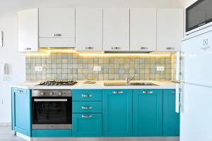 a kitchen with blue cabinets and a stove top oven at Biriola EcoResort Cala Gonone in Cala Gonone