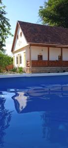 una casa con un reflejo en una piscina de agua en Kiscsermely Vendégház, en Jósvafő