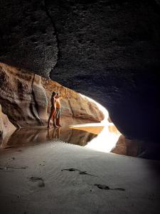 twee mensen die op het strand lopen in een grot bij RocaSol Casa d´Mar in El Zonte