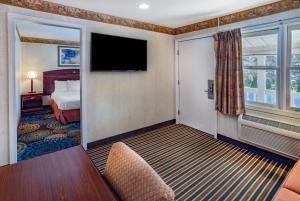 um quarto de hotel com uma cama e uma televisão de ecrã plano em Travelodge by Wyndham Great Barrington Berkshires em Great Barrington