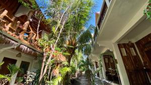 a hallway of a house with trees and plants at Sayang Mama Inn in Gili Islands