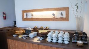 a table with cups and plates on top of it at Mawar Asri Hotel in Yogyakarta