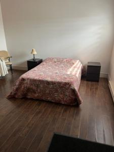 a bedroom with a bed and a wooden floor at Hôtel Motel la MInganie in Longue-Pointe-de-Mingan
