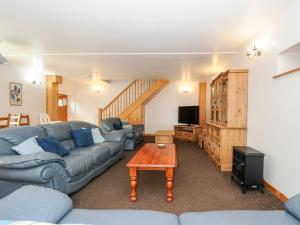 a living room with a couch and a table at The Shippon in Bude