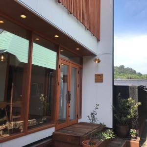 Quaint House Naoshima في ناووشيما: منزل فيه باب زجاجي و شرفه