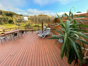 una terraza con sillas, mesas y una maceta en Casa Estela del Mar, en Pelluhue