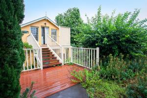 a house with a wooden deck with a white railing at Stonington Cottage Berrima in Berrima