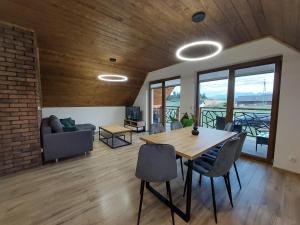 a living room with a wooden table and chairs at Domek/apartament Przekop in Sromowce Wyżne