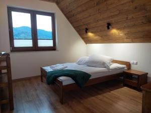 Domek/apartament Przekop في سروموس وايزين: غرفة نوم بسرير وسقف خشبي