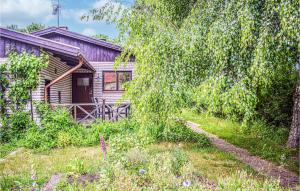 an old house with a tree and a yard at Stunning Home In Ljungbyholm With Sauna in Ljungbyholm