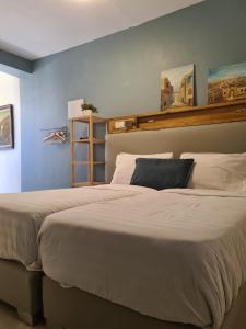 a large bed in a bedroom with a blue wall at Garden studio in El'ad