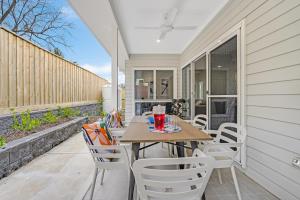 un patio con mesa y sillas en un porche en Accommodation Hunter - Bonar Street Maitland, en Maitland