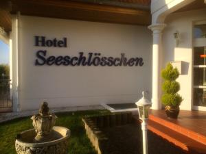 un panneau d'affichage sur le côté d'un bâtiment dans l'établissement Hotel Garni Seeschlösschen, à Kolpinsee