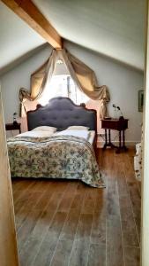 ein Schlafzimmer mit einem großen Bett mit Baldachin in der Unterkunft Ferienwohnung in seenaher Künstlervilla in Gstadt in Gstadt am Chiemsee