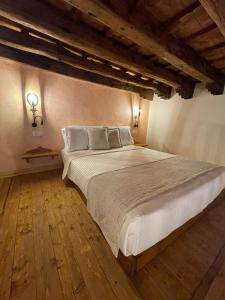 a bedroom with a large white bed with wooden floors at Midgard Suites (Medieval Town) in Rhodes Town