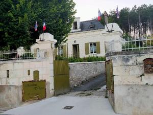 洛什的住宿－Aux trois tilleuls，栅栏上悬挂着旗帜的房子的门