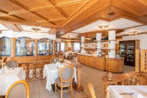 ヴィピテーノにあるHotel Rosskopfの木製の天井、テーブルと椅子のあるレストラン
