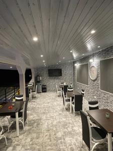 a dining room with tables and chairs and a tv at Casa Clau Cazare Orșova in Orşova