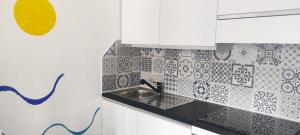 eine Küche mit weißen Schränken und einem Waschbecken in der Unterkunft Casa Conchiglia in Lido Conchiglia