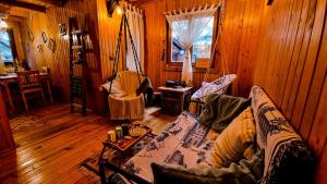 a living room with wooden floors and a couch at Tiny Wooden Cottage -Covasna in Reci