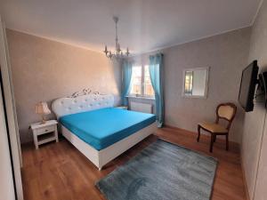 a bedroom with a blue bed and a chair at Apartment Miesmuschelparadies in Lübeck