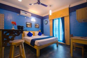 a bedroom with a bed with blue walls at Liwa Habitat in Bangalore