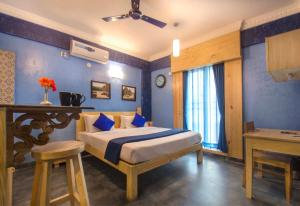 a bedroom with a bed with blue walls at Liwa Habitat in Bangalore